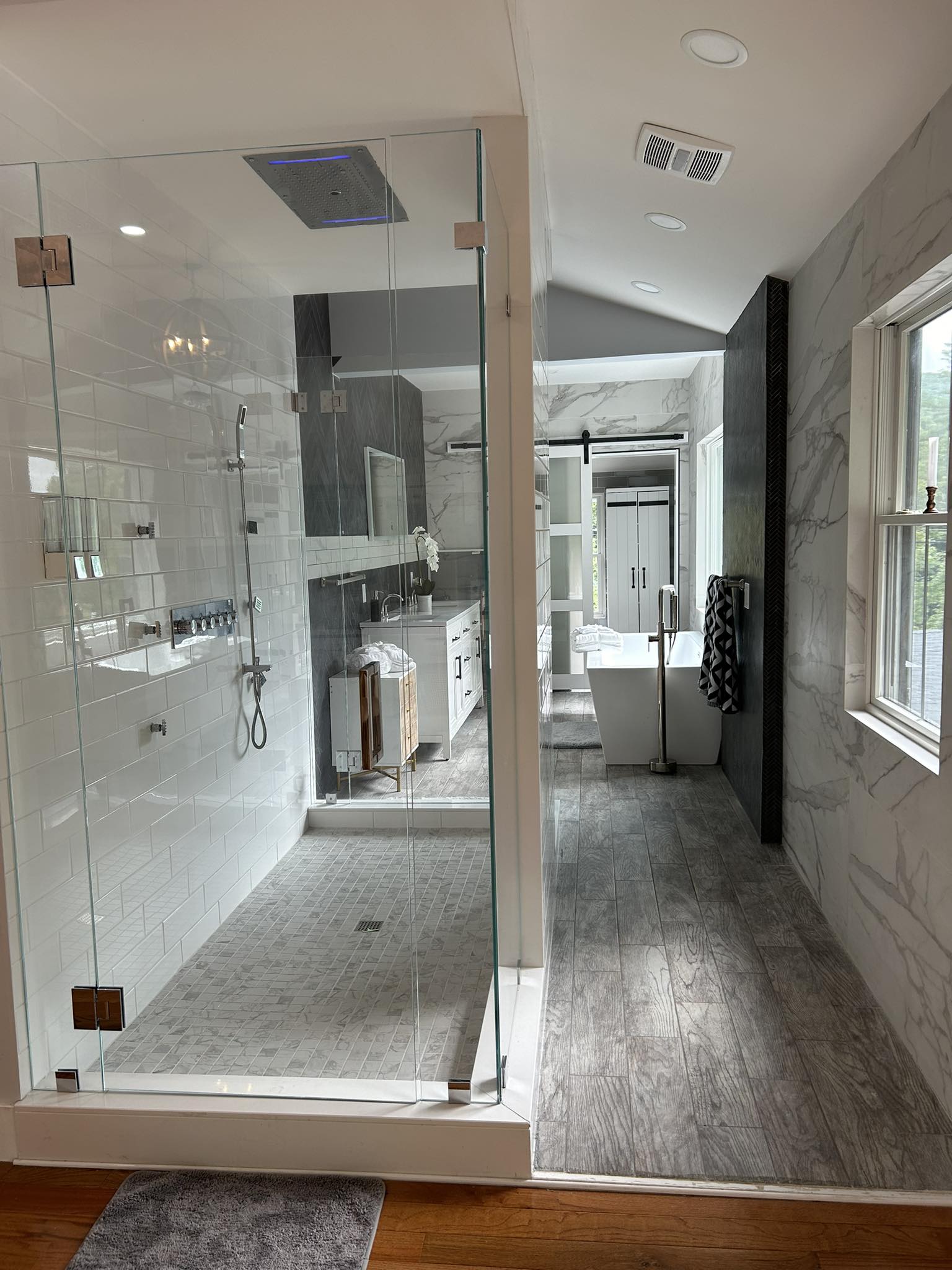 Modern bathroom renovation with tile and plank flooring