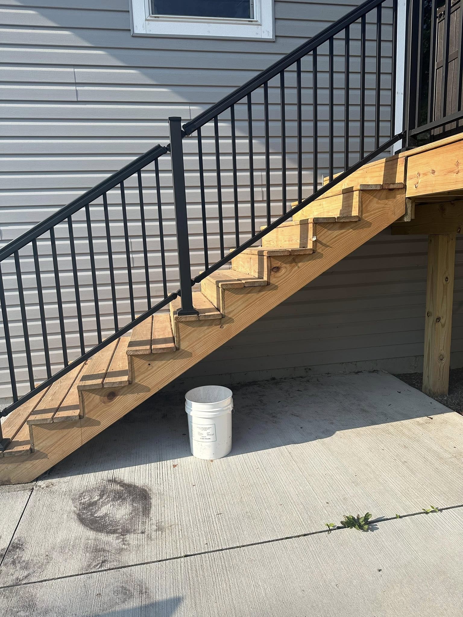 New wooden deck stairs with black metal railing