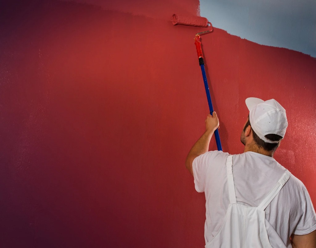 Professional painter applying paint to a wall with a roller